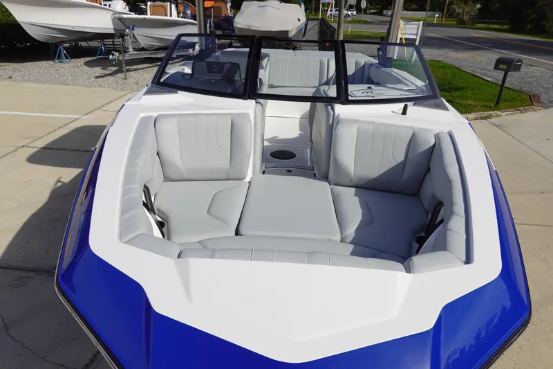 Slide: The Image of 2024 Malibu 21 LX-R boat with blue and white exterior, spacious seating. - 7