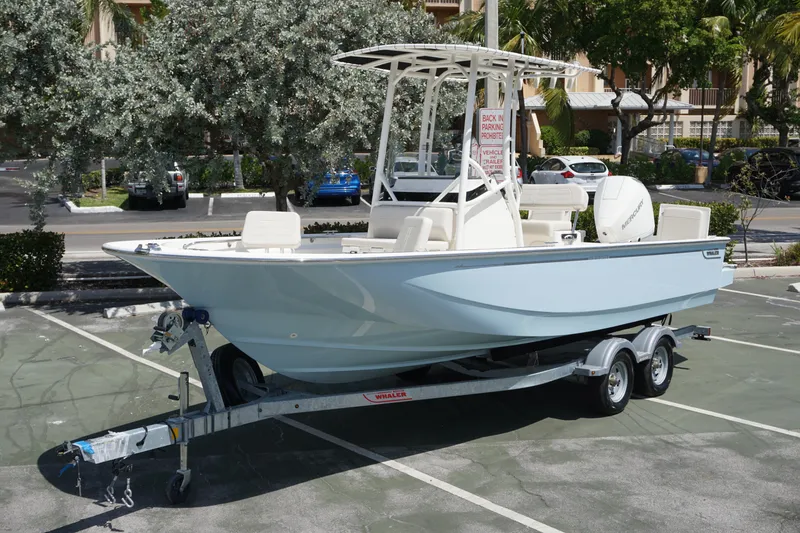 The Image of 2024 Boston Whaler 210 Montauk boat on a trailer in a parking lot. - 0