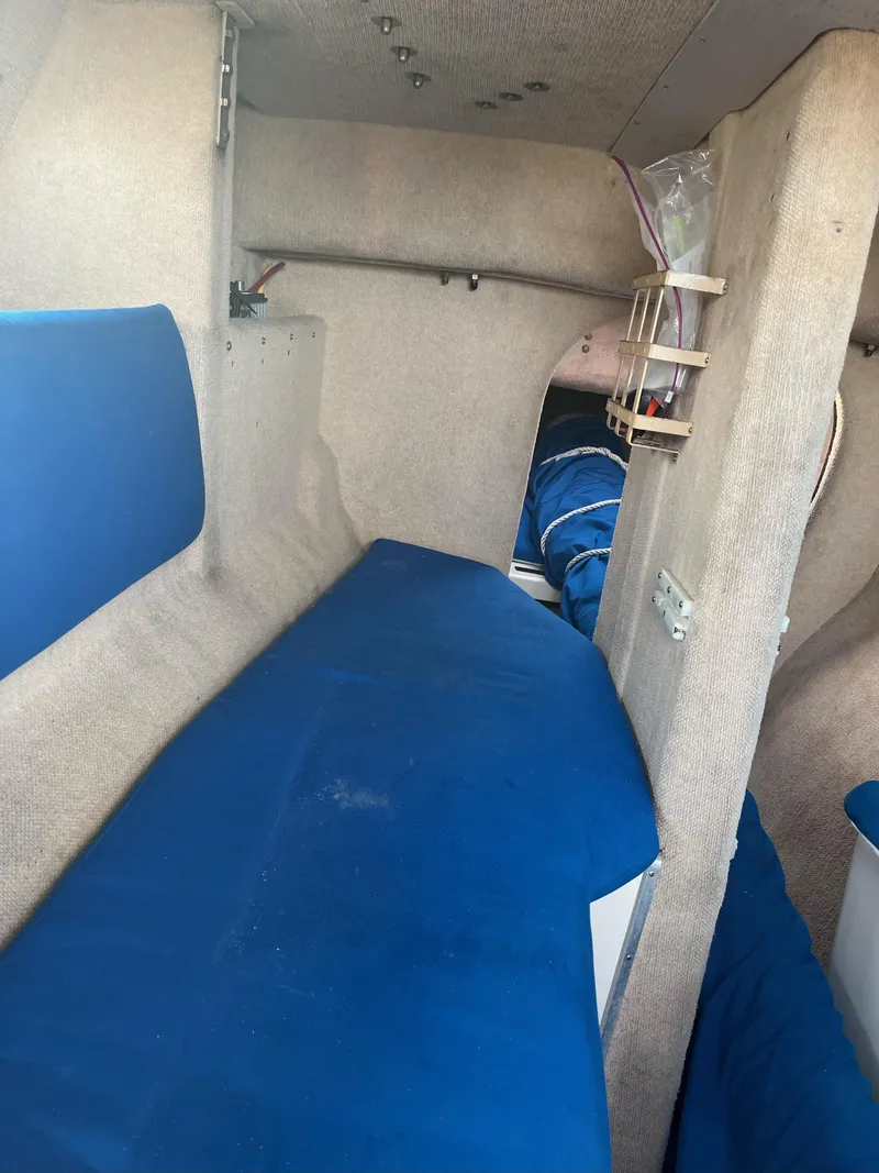 Slide: The Image of Interior of a 1991 Corsair F27 sailboat with blue cushions and beige walls. - 14