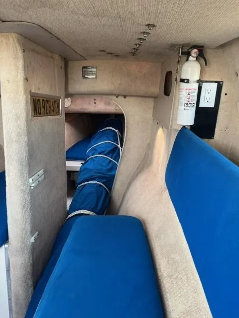 Slide: The Image of Interior of a 1991 Corsair F27 sailboat with blue seating and safety equipment. - 6
