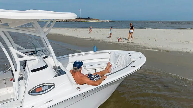 Slide: The Image of 2025 Sea Fox 248 Side Console boat anchored near a beach with people relaxing. - 12