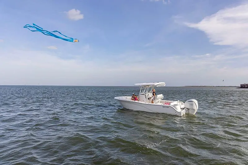 Slide: The Image of 2025 Sea Fox 248 Side Console boat cruising on open water with a kite flying. - 23