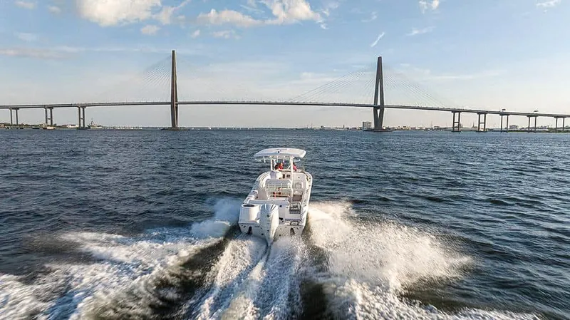 Slide: The Image of 2025 Sea Fox 248 Side Console boat cruising under a bridge on a sunny day. - 27