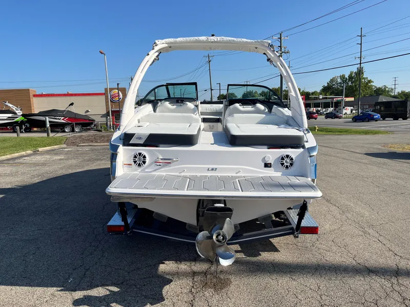 Slide: The Image of 2024 Regal LS2 boat, rear view, parked outdoors on a sunny day. - 14