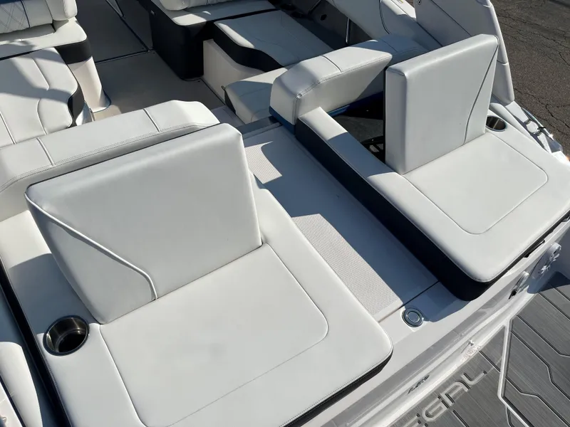 Slide: The Image of 2024 Regal LS2 boat interior with white cushioned seating and cup holders. - 2