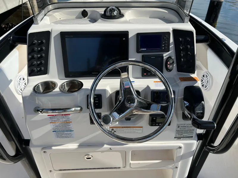Slide: The Image of 2018 Robalo 246 Cayman boat interior with steering console and seating. - 1