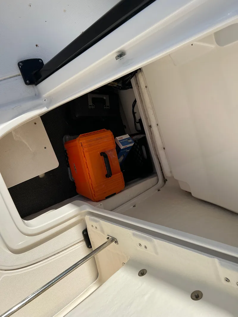 Slide: The Image of 2018 Robalo 246 Cayman boat cruising on clear water with flags displayed. - 11