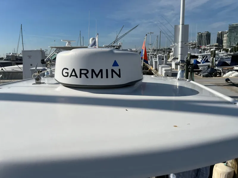 Slide: The Image of 2018 Robalo 246 Cayman boat cruising on water with flags displayed. - 12