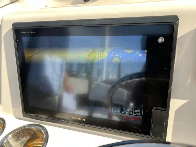 Slide: The Image of 2018 Robalo 246 Cayman boat dashboard with navigation system on open water. - 15