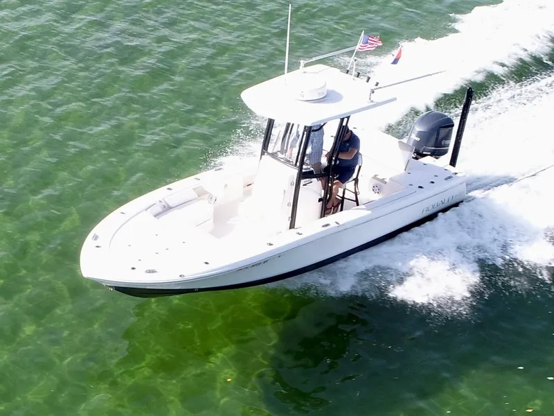 Slide: The Image of 2018 Robalo 246 Cayman boat interior with seating and storage, parked outdoors. - 3