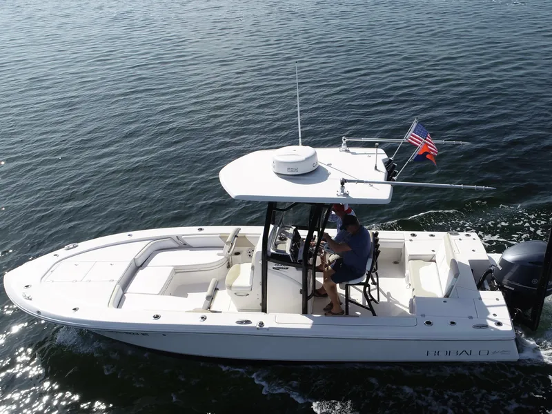 Slide: The Image of 2018 Robalo 246 Cayman boat interior with seating and console, outdoors. - 6