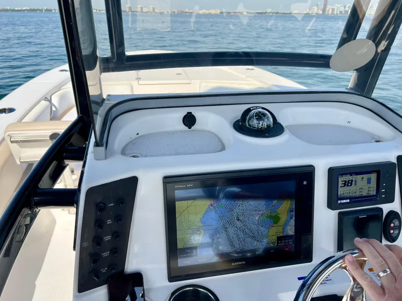 Slide: The Image of 2018 Robalo 246 Cayman boat cruising on clear green water. - 9
