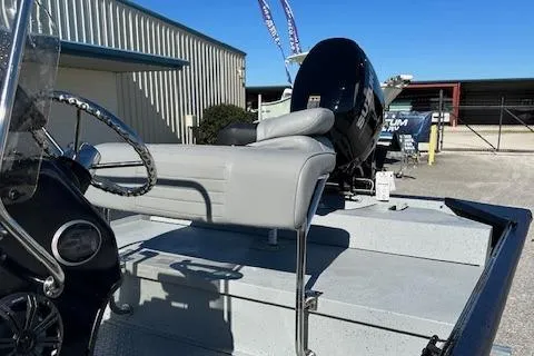 Slide: The Image of 2024 SeaArk RXT 180 boat with steering console and seating, parked outdoors. - 11