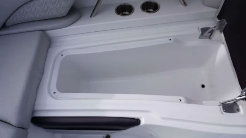 Slide: The Image of 2024 Hurricane 2600 SD boat storage compartment with cup holders and cushioned seating. - 12