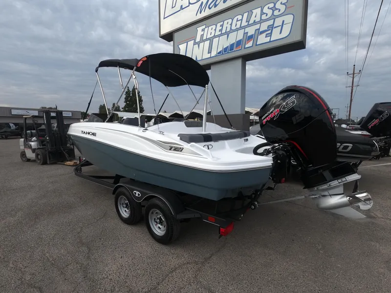 Slide: The Image of 2024 Tahoe T21 boat on trailer with outboard motor at dealership. - 2