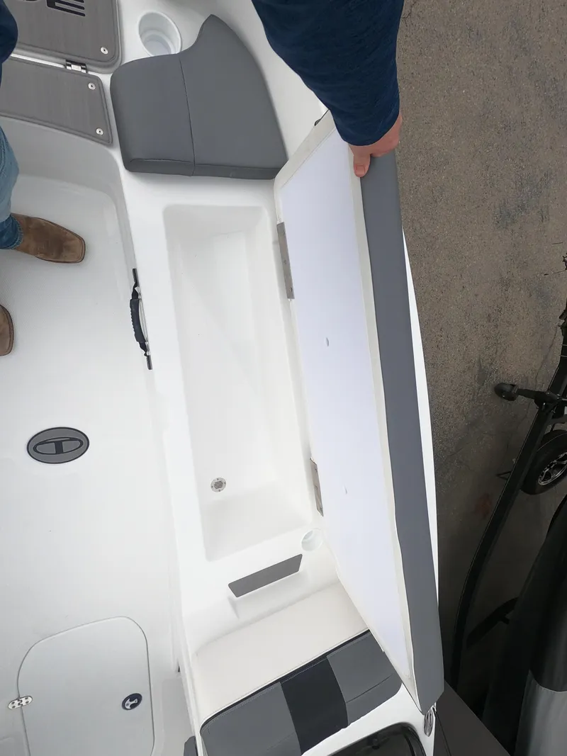 Slide: The Image of 2024 Tahoe T21 boat interior storage compartment with gray and white seating. - 24