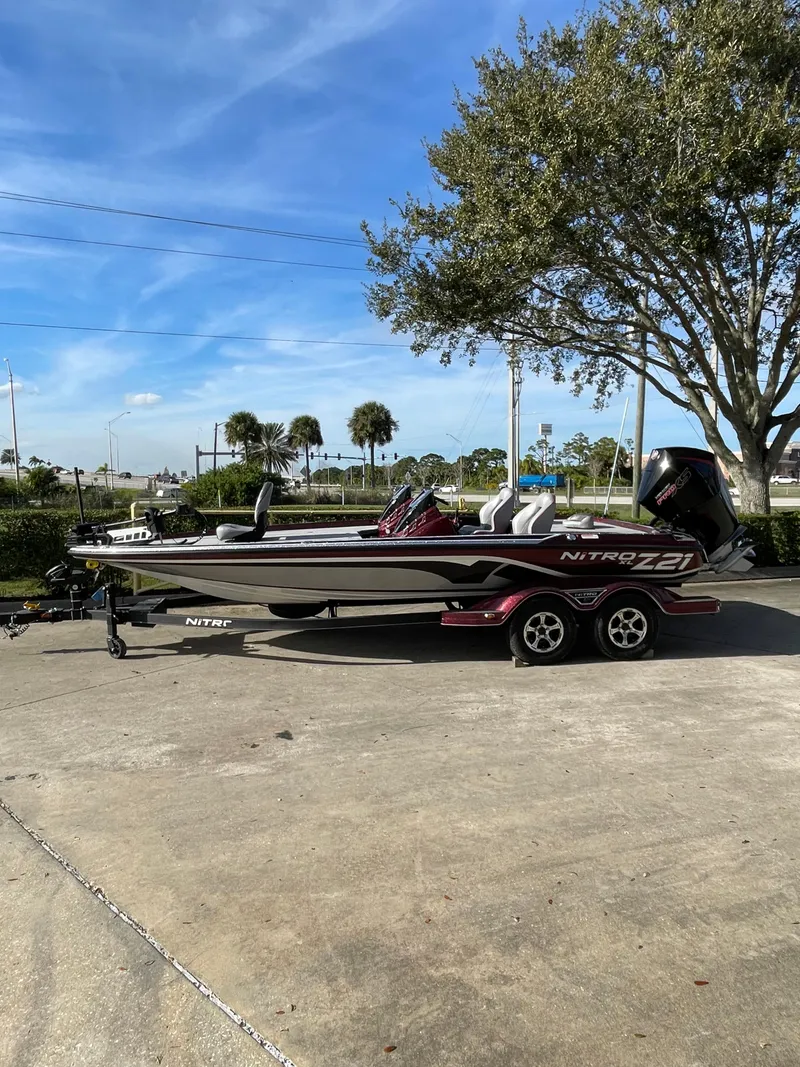 Slide: The Image of 2024 Nitro Z21 XL bass boat parked outdoors. - 1