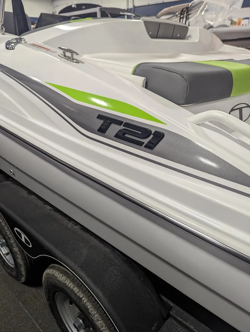 Slide: The Image of 2024 Tahoe T21 boat with sleek design and green accents on trailer. - 2
