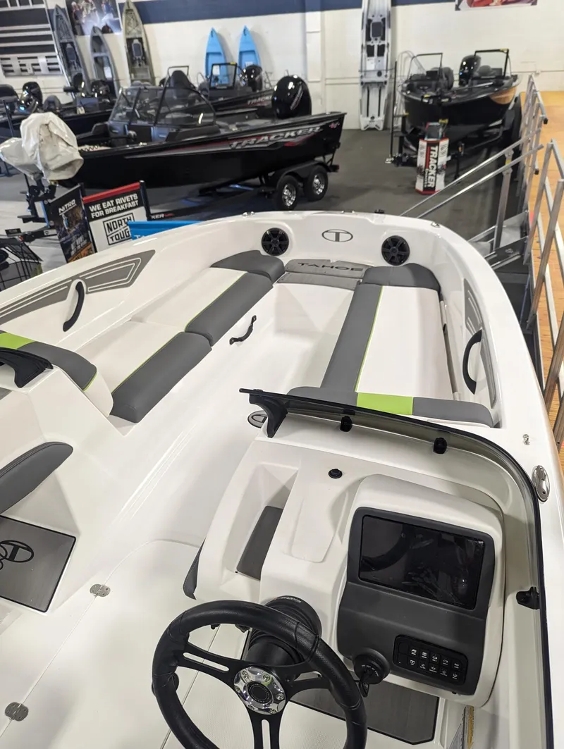 Slide: The Image of 2024 Tahoe T21 boat interior with steering wheel and seating, displayed in a showroom. - 3