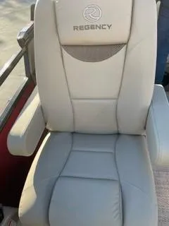 Slide: The Image of 2024 Regency 230 LE3 Sport boat seat with armrests and logo. - 11