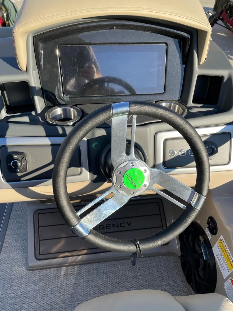Slide: The Image of 2024 Regency 230 LE3 Sport boat dashboard with steering wheel and control panel. - 13