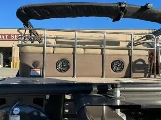 Slide: The Image of 2024 Regency 230 LE3 Sport pontoon boat with beige seating and black canopy. - 4