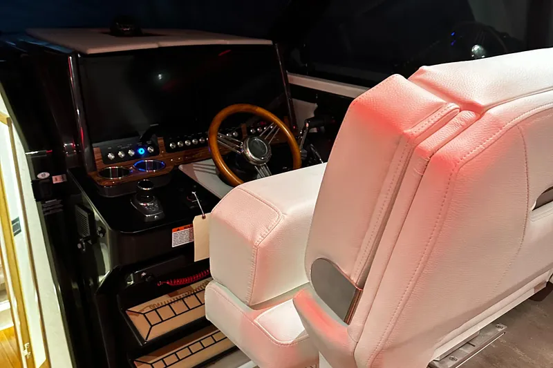 Slide: The Image of 2023 Tiara Yachts 43 LE helm station with white leather seats and wooden steering wheel. - 13