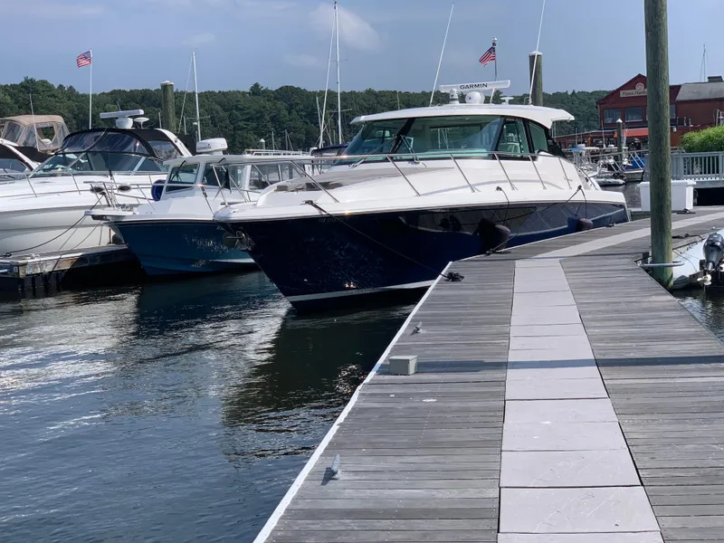 Slide: The Image of 2023 Tiara Yachts 43 LE docked at a marina. - 2
