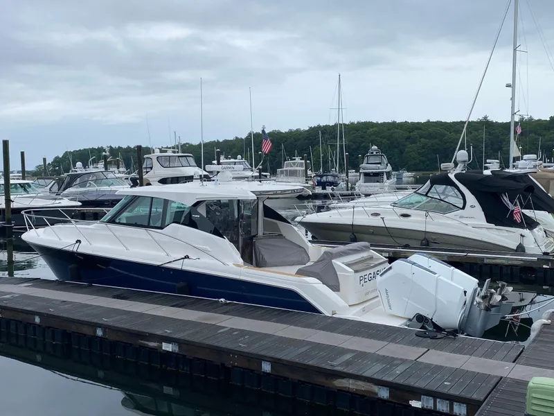 Slide: The Image of 2023 Tiara Yachts 43 LE docked at a marina with other boats. - 4