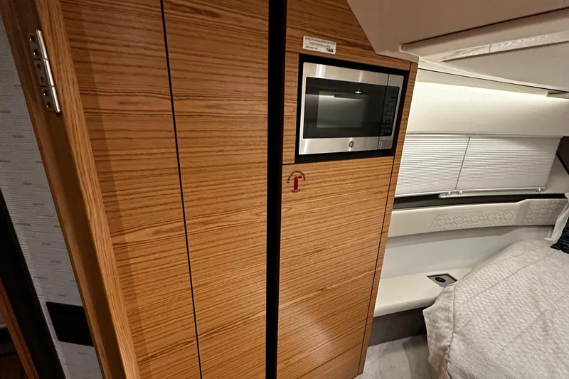 Slide: The Image of 2023 Tiara Yachts 43 LE interior with wood cabinetry and built-in microwave. - 7