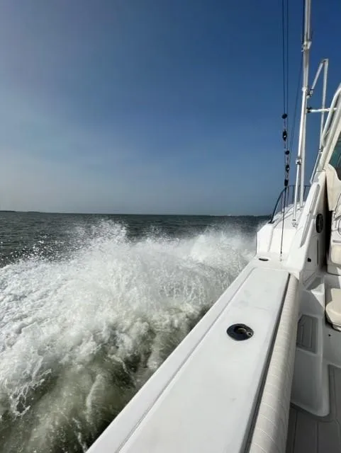 Slide: The Image of 1991 Tiara Yachts 4300 Open cruising on open water, creating a splash. - 10