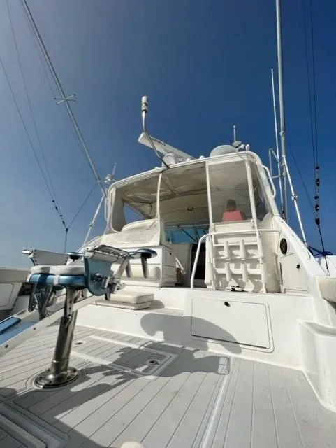 Slide: The Image of 1991 Tiara Yachts 4300 Open, white exterior, fishing rods, clear sky background. - 13