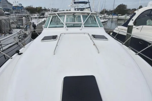 Slide: The Image of 1991 Tiara Yachts 4300 Open docked in a marina, showcasing its spacious deck. - 19