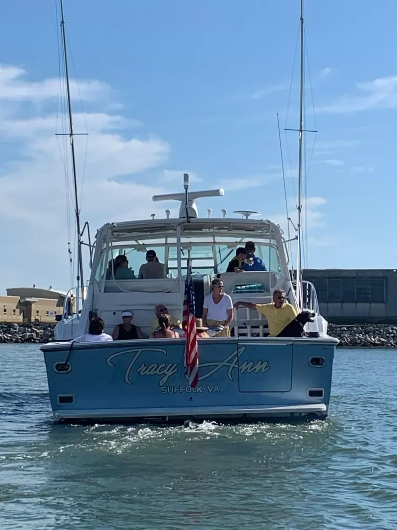 Slide: The Image of 1991 Tiara Yachts 4300 Open cruising with passengers, displaying "Tracy Ann" and American flag. - 2