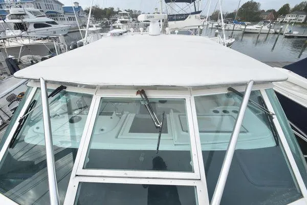 Slide: The Image of 1991 Tiara Yachts 4300 Open at marina, showcasing helm and windshield. - 20