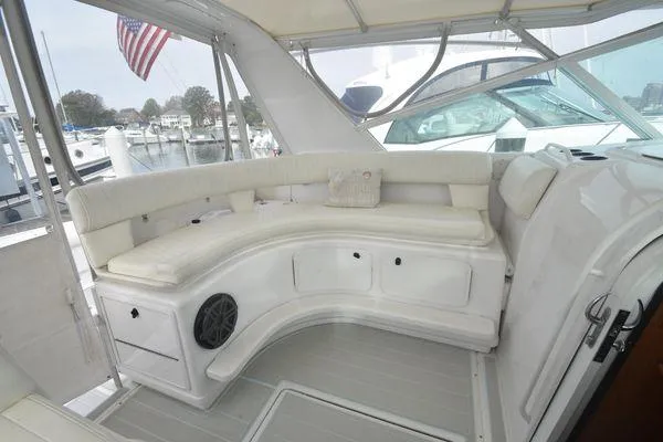 Slide: The Image of 1991 Tiara Yachts 4300 Open with white seating area and American flag in marina. - 21