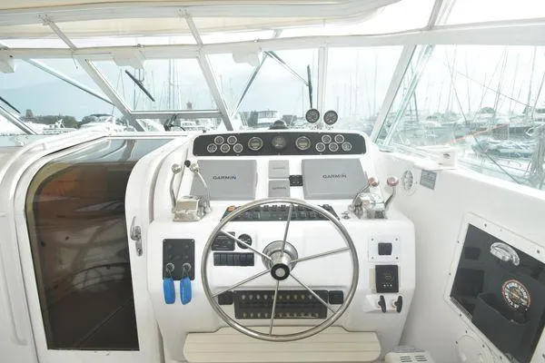 Slide: The Image of 1991 Tiara Yachts 4300 Open helm with steering wheel and navigation instruments. - 23