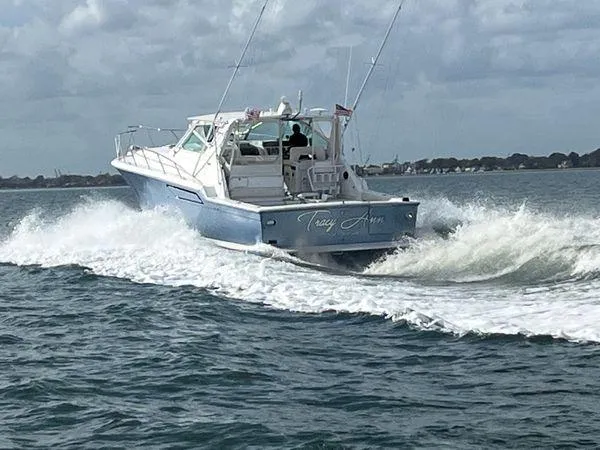 Slide: The Image of 1991 Tiara Yachts 4300 Open cruising on the water, creating a wake. - 3