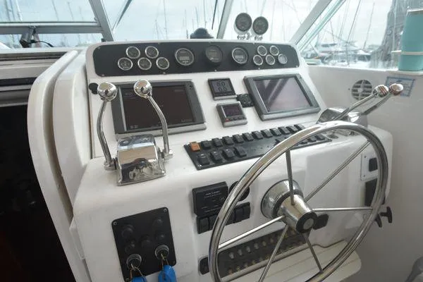 Slide: The Image of 1991 Tiara Yachts 4300 Open helm with steering wheel and control panel. - 32