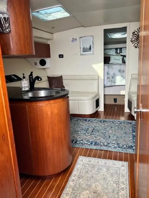 Slide: The Image of Interior of a 1991 Tiara Yachts 4300 Open, featuring wood finishes and cozy seating. - 40