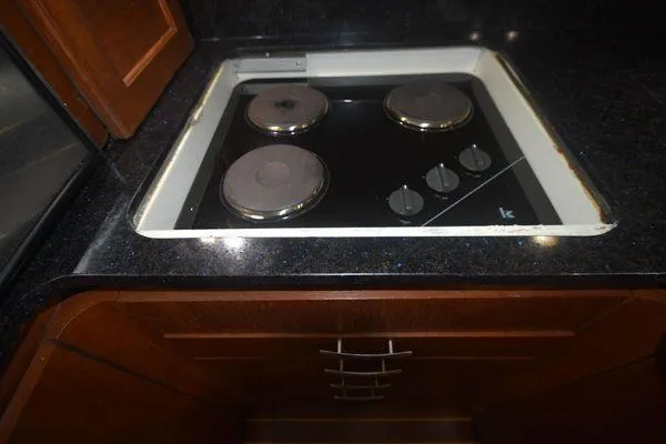 Slide: The Image of 1991 Tiara Yachts 4300 Open kitchen with electric stovetop and dark countertop. - 45