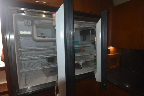 Slide: The Image of Open refrigerator inside a 1991 Tiara Yachts 4300 Open, showcasing interior shelves. - 46