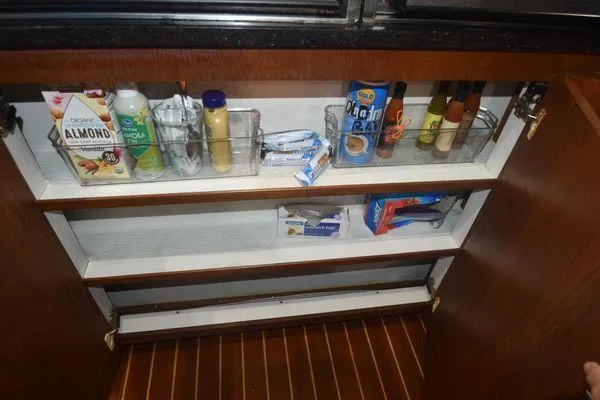 Slide: The Image of 1991 Tiara Yachts 4300 Open kitchen cabinet with organized pantry items. - 47
