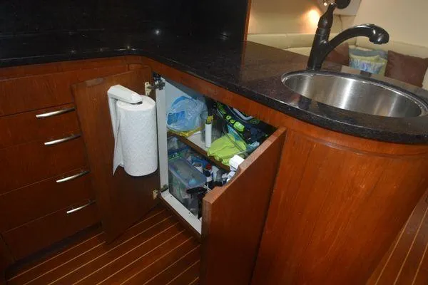 Slide: The Image of 1991 Tiara Yachts 4300 Open kitchen with wooden cabinets and stainless steel sink. - 49