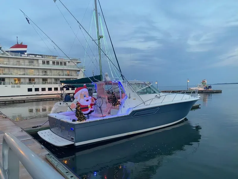 Slide: The Image of 1991 Tiara Yachts 4300 Open decorated with festive lights and Santa inflatable at dock. - 7