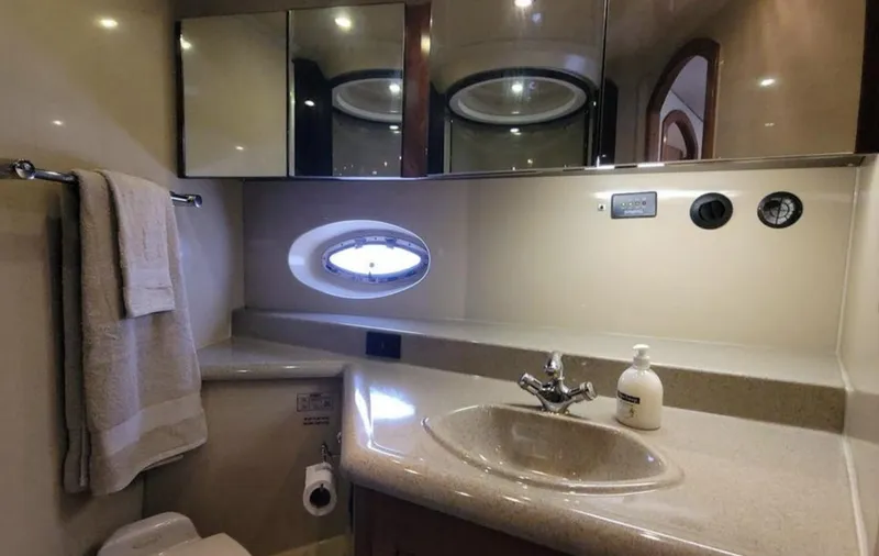 Slide: The Image of Luxurious bathroom in 2003 Cruisers Yachts 4370 Express with oval window and modern fixtures. - 10