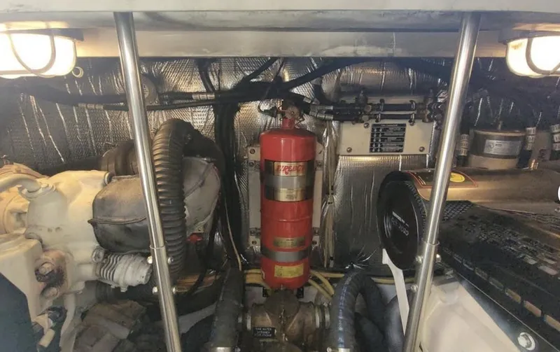 Slide: The Image of Engine room of 2003 Cruisers Yachts 4370 Express with fire extinguisher and mechanical components. - 16