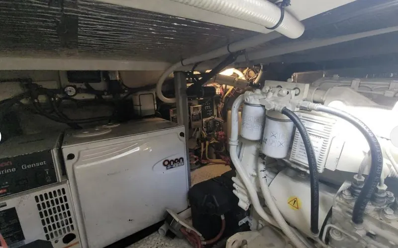 Slide: The Image of Engine room of 2003 Cruisers Yachts 4370 Express, featuring generator and mechanical components. - 17