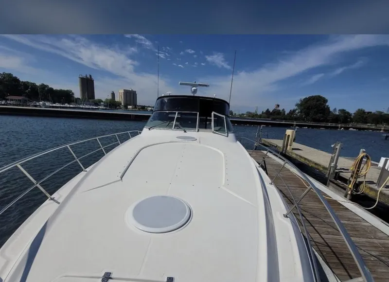 Slide: The Image of 2003 Cruisers Yachts 4370 Express docked, showcasing sleek design and spacious deck. - 6