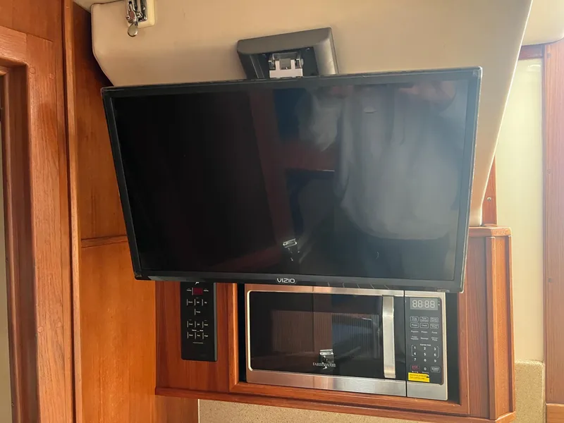 Slide: The Image of 2005 Albemarle 310 Express Fisherman cabin with blue seating and wooden table. - 14